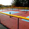 Yellow poly-cap installed on pickleball court fence