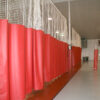 Row of red hanging punching bags along a gym hallway.