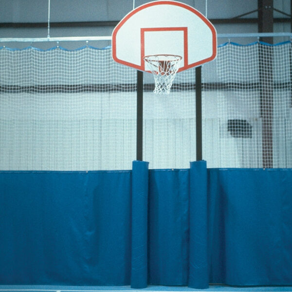 Indoor basketball hoop mounted on a black pole with a white backboard and net, set against a blue padded wall and safety netted barrier.